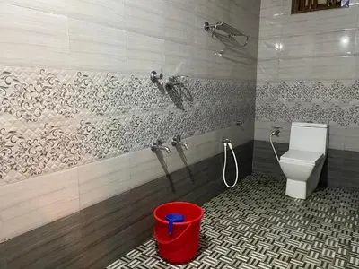 a bathroom with a toilet and a bucket in it at Misty Night Wayanad Pool Resort in Wayanad