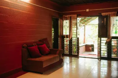a living room with a couch and a sliding glass door at Misty Night Wayanad Pool Resort in Wayanad