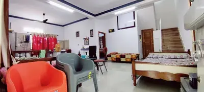 a bedroom with a bed and chairs in a room at Nature stay GF in Hārohalli