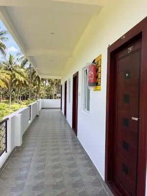 a corridor of a house with a wooden door at The coconest Kinathukadavu, Coimbatore in Kinattukkadavu