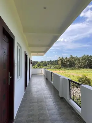 a balcony of a house with a view of a field at The coconest Kinathukadavu, Coimbatore in Kinattukkadavu