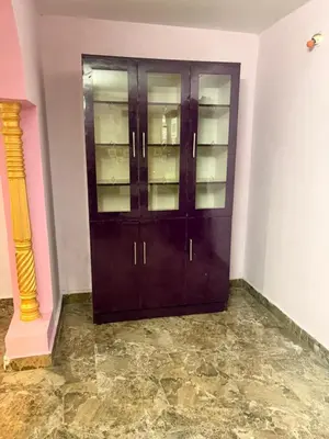 a dark wooden cabinet in a room with a marble floor at The Green residence in Mysore