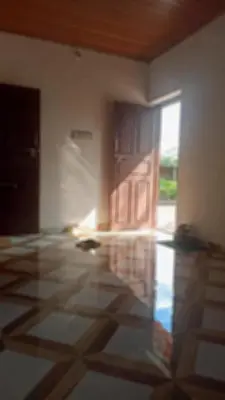 an empty room with a door and a tile floor at Bakka house of joy in Napoklu