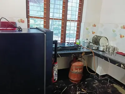 a kitchen with a stove and a counter top at Bakka house of joy in Napoklu