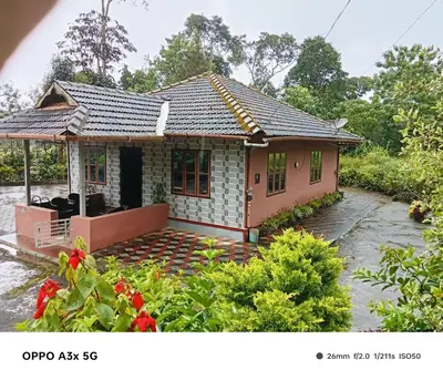 a small house in the middle of a garden at Bakka house of joy in Napoklu