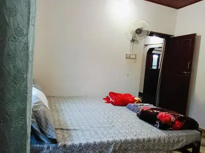 a bedroom with a bed with a lamp and a mirror at Bakka house of joy in Napoklu