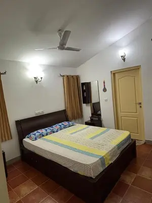 a bedroom with a bed and a yellow door at SARA fARM STAY