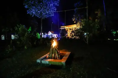 a fountain in the middle of a yard at night at DJ River Meadows Resort in Wayanad