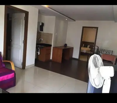 a living room with a couch and a fan at Mysore Central 3bhk serviced apartment in Mysore