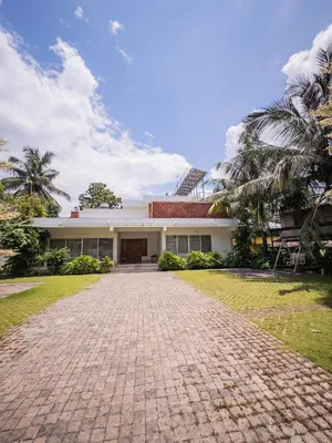 a house with a brick driveway in front of it at Akshaya Homestay in Trichūr