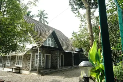 a brick house with a gambrel roof at Villa La Vista Homestay in Calicut