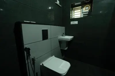 a bathroom with a toilet and a sink and a window at Villa La Vista Homestay in Calicut