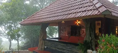 a small house with a roof on top of it at Naturia in Ambalavayal