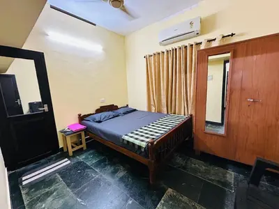 a bedroom with a bed and a mirror in it at Bluebell Homes B- 2bhk Upstairs in Kozhikode