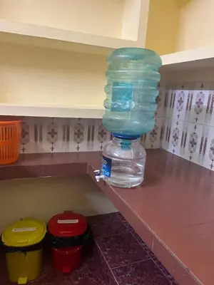 a bottle of water sitting on a shelf in a kitchen at Bluebell Homes B- 2bhk Upstairs in Kozhikode