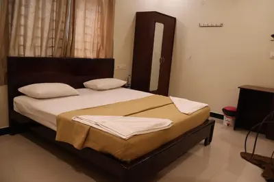 a bedroom with a large bed with white sheets and pillows at SPICE HOMESTAY Apartment in Singānallūr
