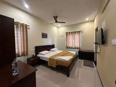 a bedroom with a bed and a flat screen tv at SPICE HOMESTAY Apartment in Singānallūr