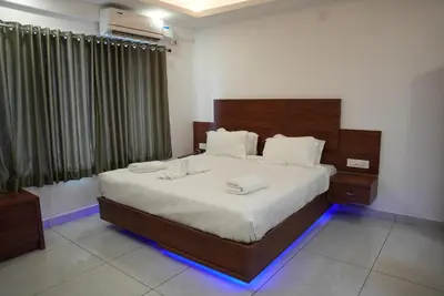a bedroom with a large bed with white sheets at Pearl Residency Kalady in Kāladi