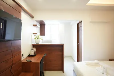 a bedroom with a desk and a bed and a sink at Pearl Residency Kalady in Kāladi