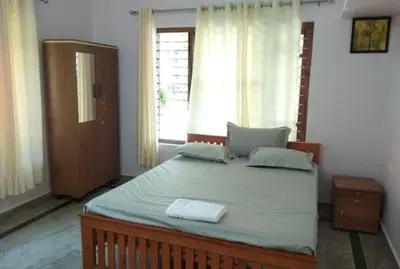 a bedroom with a large bed with two towels on it at Malayil Peacock Villa in Wayanad