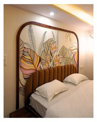 a bed with a large head board with a mural at Event House, Mysore in Mysore