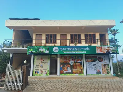 a building with a green sign in front of it at Anna rooms in Chekadi
