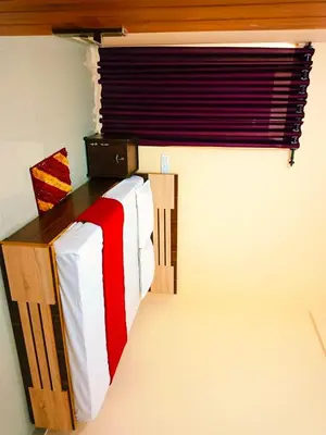 a bed in a room with a window and a table at Anna rooms in Chekadi