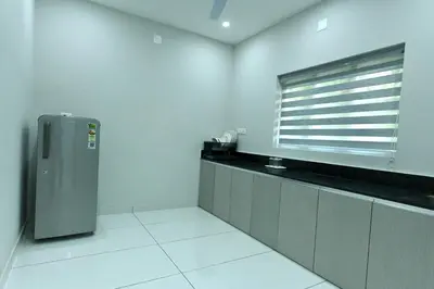 a kitchen with a refrigerator and a window at Star Guest House