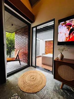 a living room with a large sliding glass door at GINGY Holidays in Wayanad