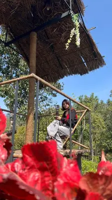 a man sitting in a chair in a straw hut at Mount Lux Villa in Devāla