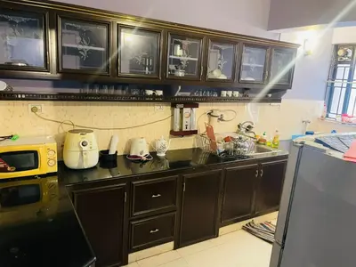 a kitchen with dark brown cabinets and a sink at 2BHK Apartment in Central Thrissur in Trichūr