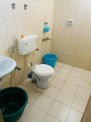 a bathroom with a toilet and a sink at 2BHK Apartment in Central Thrissur in Trichūr