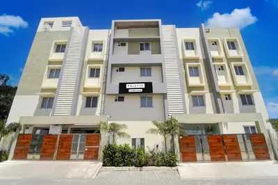 a tall white building with a sign on it at Palette Serenity by CheckIn | 2 BHK Apartment | Coimbatore in Coimbatore