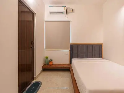 a small bedroom with a bed and a window at Palette Serenity by CheckIn | 2 BHK Apartment | Coimbatore in Coimbatore