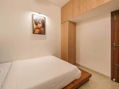 a bedroom with a bed and a picture on the wall at Palette Serenity by CheckIn | 2 BHK Apartment | Coimbatore in Coimbatore