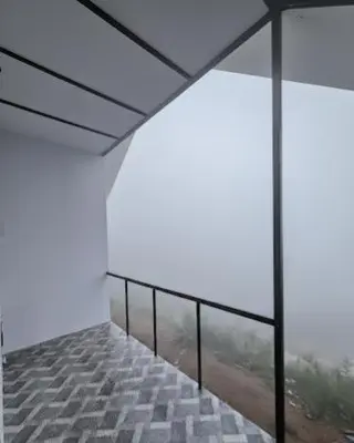 an empty room with a balcony with a view at Tribano vattavada in Vattavada