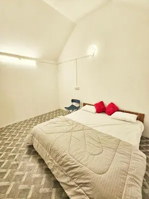 a bedroom with a large bed with red pillows at Tribano vattavada in Vattavada