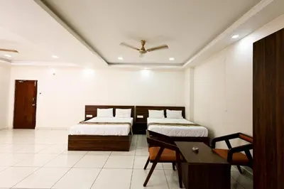 a bedroom with two beds and a table and a ceiling at SSR Comforts in Mandya