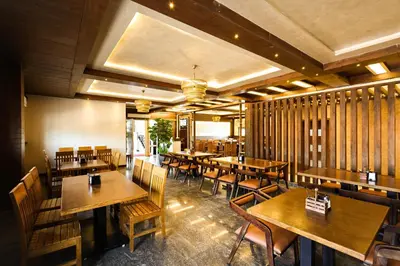 a dining room with wooden tables and chairs at SSR Comforts in Mandya