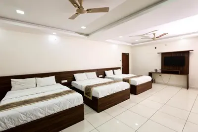 a hotel room with two beds and a television at SSR Comforts in Mandya