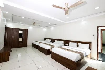 a room with three beds and a ceiling fan at SSR Comforts in Mandya