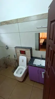 a bathroom with a toilet and a sink at Dolmens castle in Marayoor