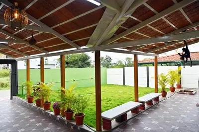 a pavilion with benches and plants on a tennis court at Suhas Nest in Mysore