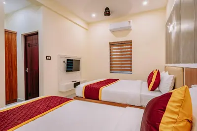 a bedroom with two beds and a window at Victoria Suites Airport Hotel in Nedumbassery
