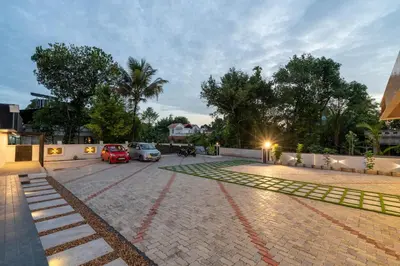 a parking lot with parked cars and a building at Victoria Suites Airport Hotel in Nedumbassery