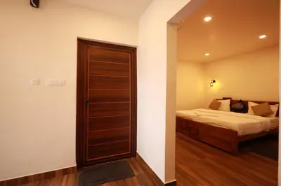 a bedroom with a bed and a wooden door at MT'S Villas in Batheri