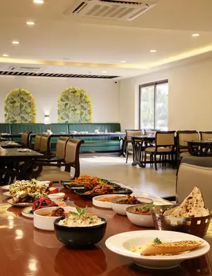 a table with many plates of food on it at Parays Fernwoods in Mannārakkāt