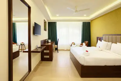 a hotel room with a bed and a mirror at Parays Fernwoods in Mannārakkāt