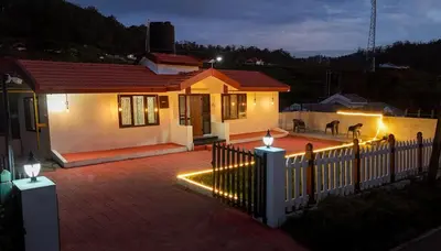 a house with a fence with lights on it at Hertz home in Ooty