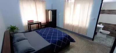 a bedroom with a blue bed and a bathroom at Perch by the sea 2 in Kannur